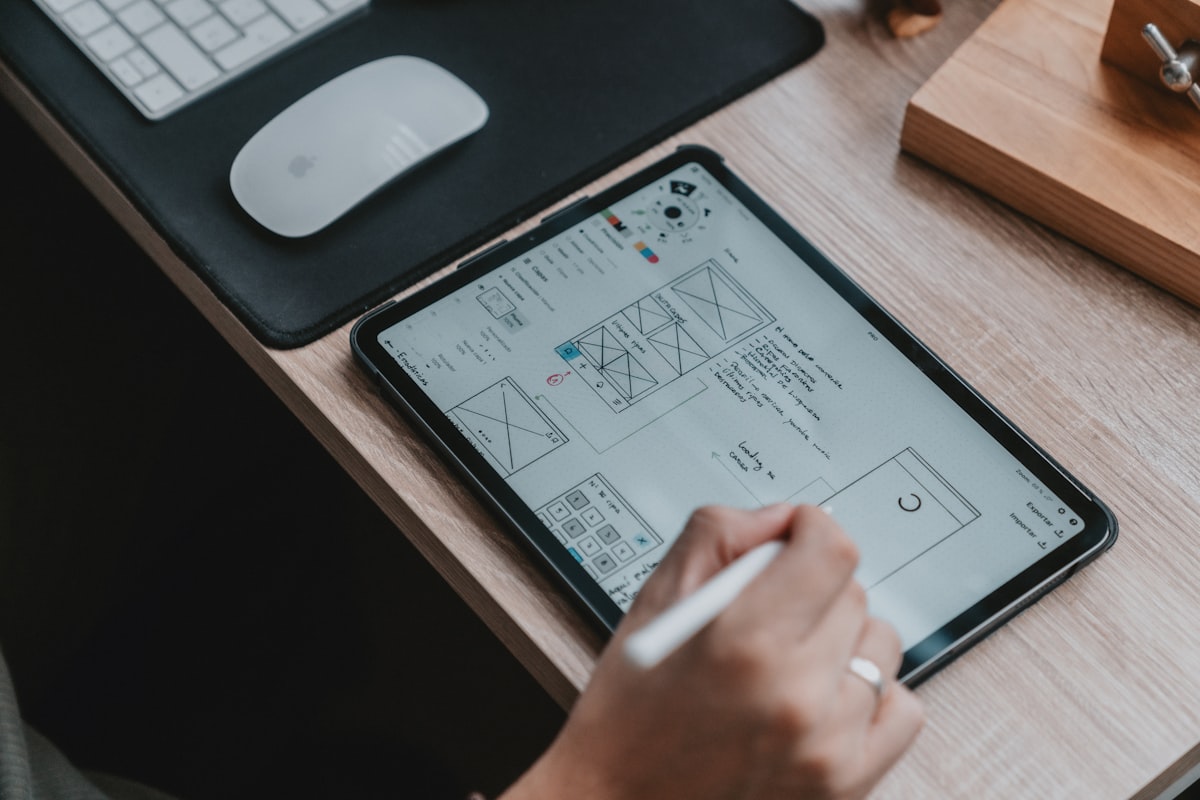 A designer's workspace with wireframes and UX sketches representing the intersection of human creativity and AI-powered design tools
