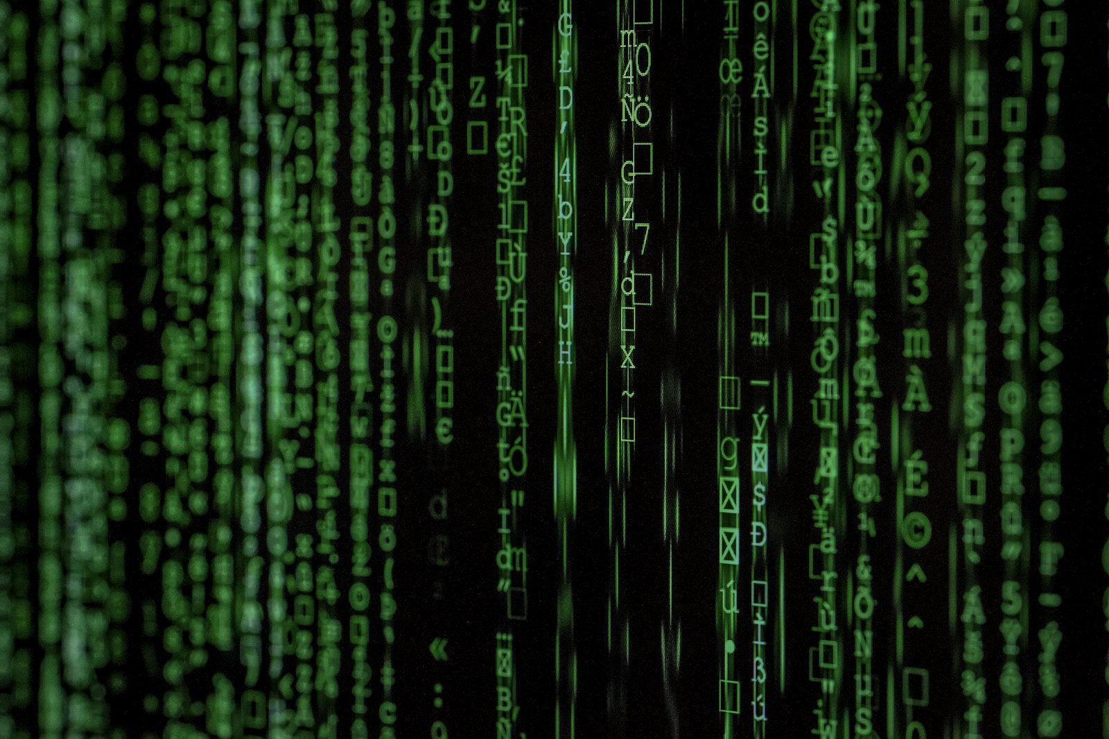 Green digital rain Matrix-style code cascading down a dark screen, representing AI breaking through digital barriers