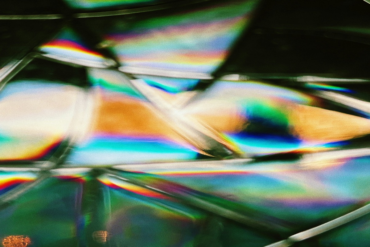 Light refracting through layered glass into a spray of color — the same object reading differently under different light, the way one Icon Composer document renders as light, dark, clear, and tinted.