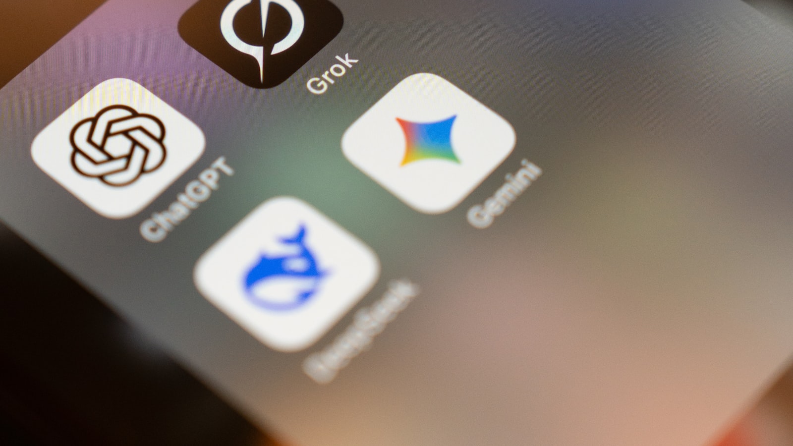A smartphone screen showing AI app icons including ChatGPT, Gemini, Grok, and DeepSeek — representing the new iOS 27 Extensions model choice