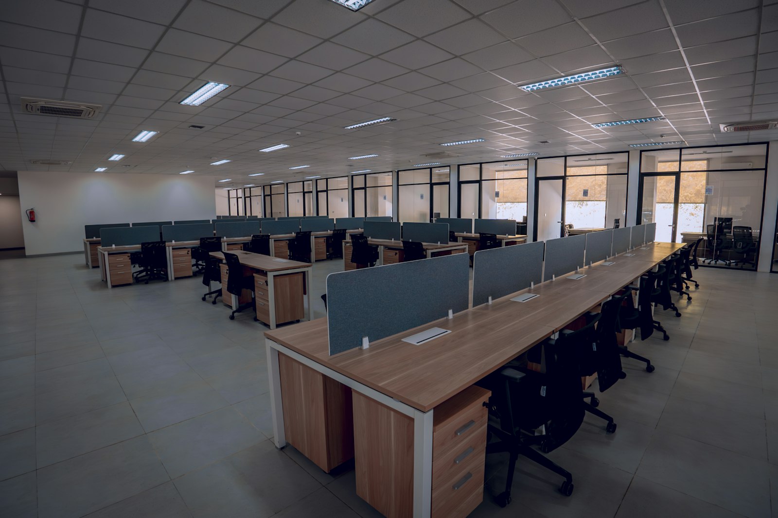 Empty office desks and chairs in a modern workspace — representing the vanishing junior developer positions