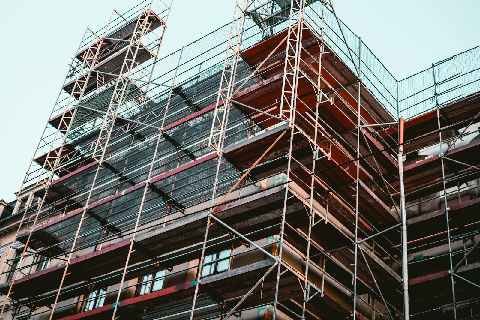 A building wrapped in scaffolding mid-renovation — the new facade isn't up yet, so the old one stays protected. The same call you make with UIDesignRequiresCompatibility while your redesign is still in flight.