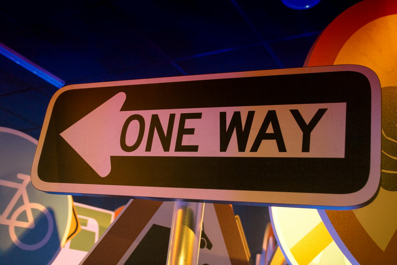 A glowing 'One Way' street sign at night — a visual metaphor for Swift 6.2 making the main actor the default direction