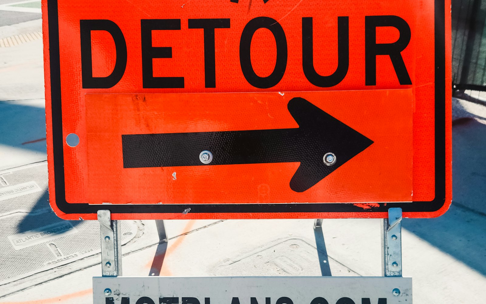 A bright orange DETOUR road sign with a black arrow pointing right — the moment a request reroutes from the on-device model to the server.