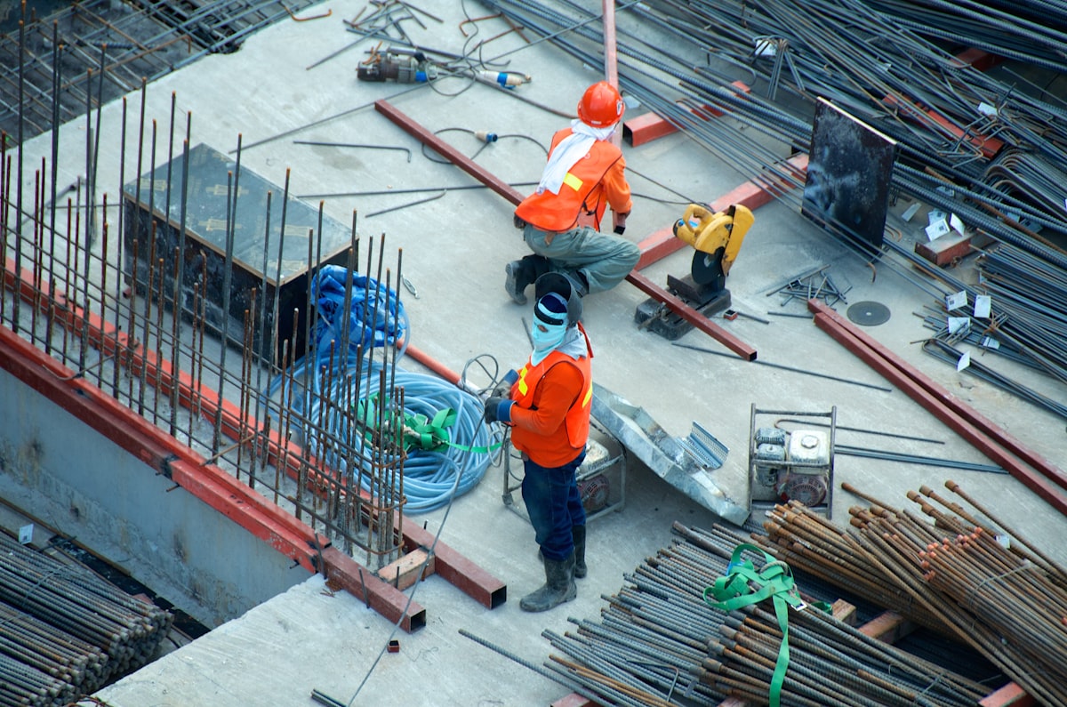 Construction workers on a building site with exposed rebar and concrete — the rebuild has begun