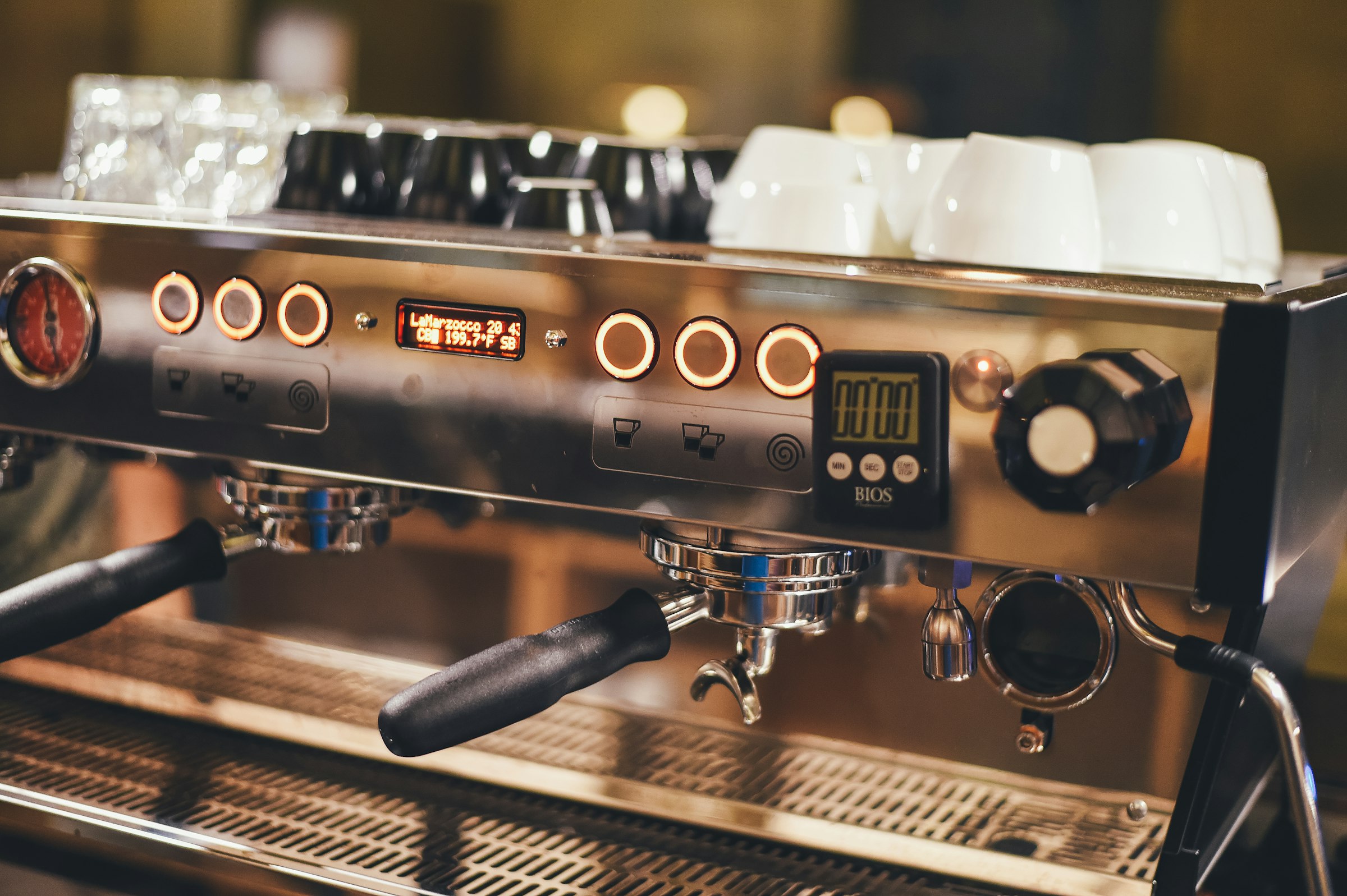 Close-up of an espresso machine's row of glowing buttons — press one, skip the rest of the ceremony, which is the entire pitch of an App Intent.