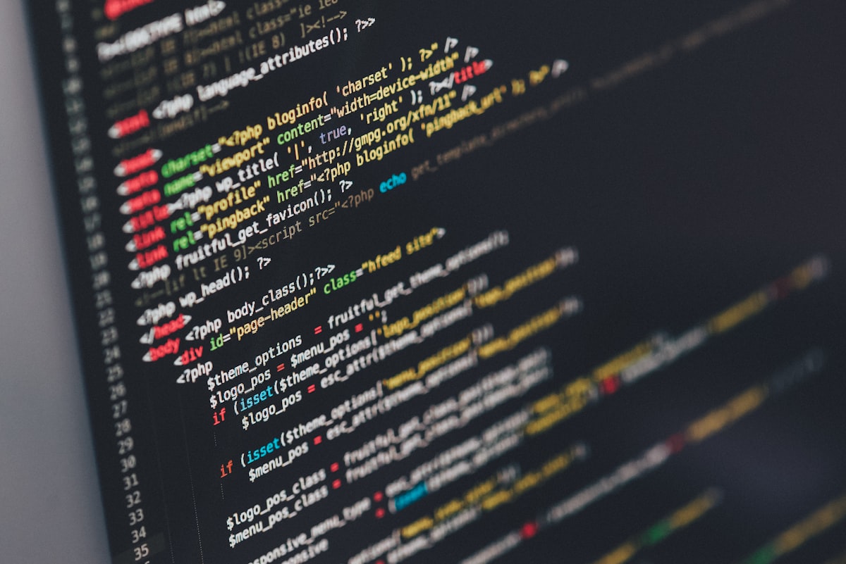 A monitor displaying lines of code in a dark IDE — representing the developer experience of working with Xcode's updated AI coding agent