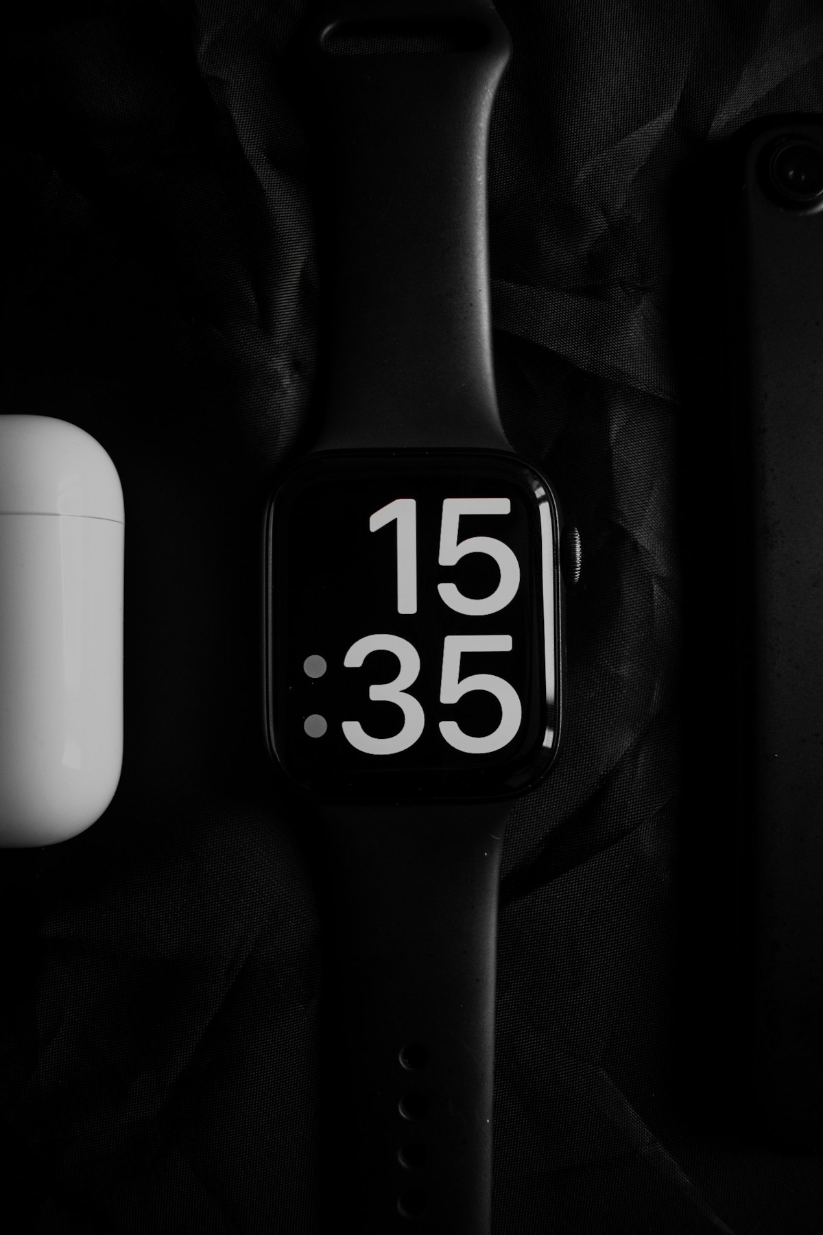 A close-up black and white photograph of a mechanical stopwatch — the kind a track coach would hold, not a Rolex — face-on, hands frozen mid-second.